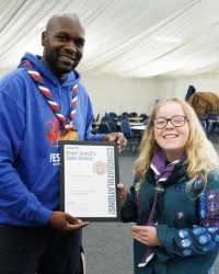 a scout is awarded their Gold Award by UK Chief Scout Dwayne Fields