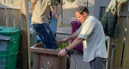 An explorer crushes garden waste in a bin