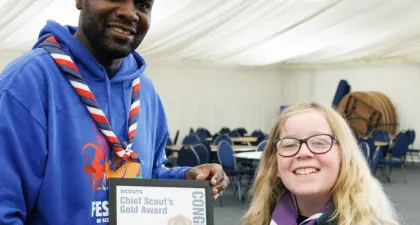 a scout is awarded their Gold Award by UK Chief Scout Dwayne Fields
